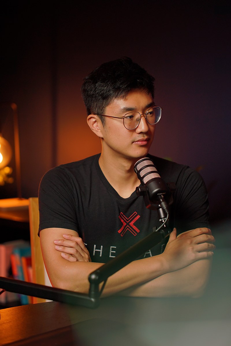Eric Z. Yang, founder of Unlimited Podcast Bangkok, at a broadcast microphone in the studio